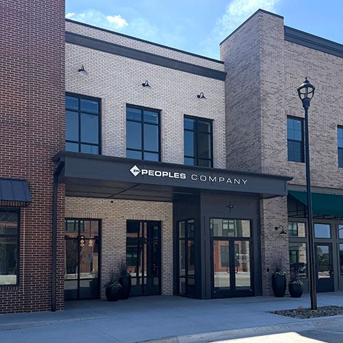 The Peoples Company corporate office, a pale brick building with the company name across its entry canopy